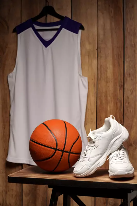 white-sneakers-basketball-ball-against-wooden-background